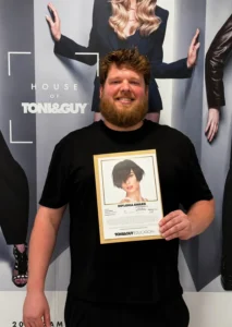 John Drimmie holding a TONI&GUY diploma education certificate